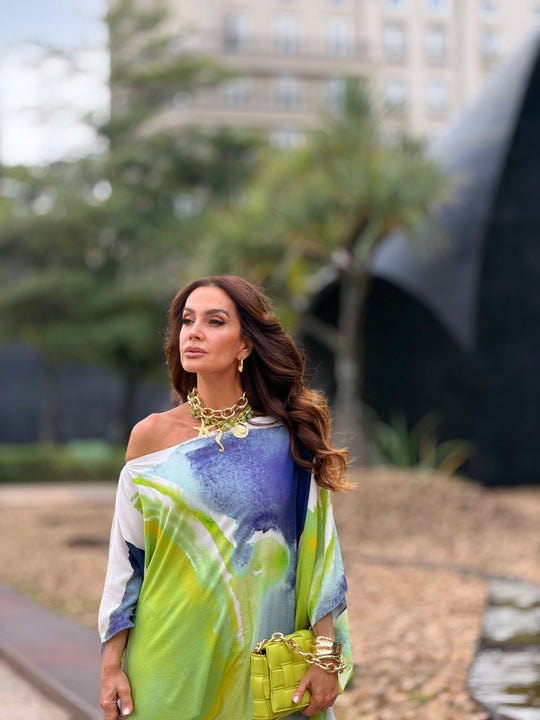 Mulher usando kaftan estampado aquarela em tons de verde, azul e branco ao ar livre
