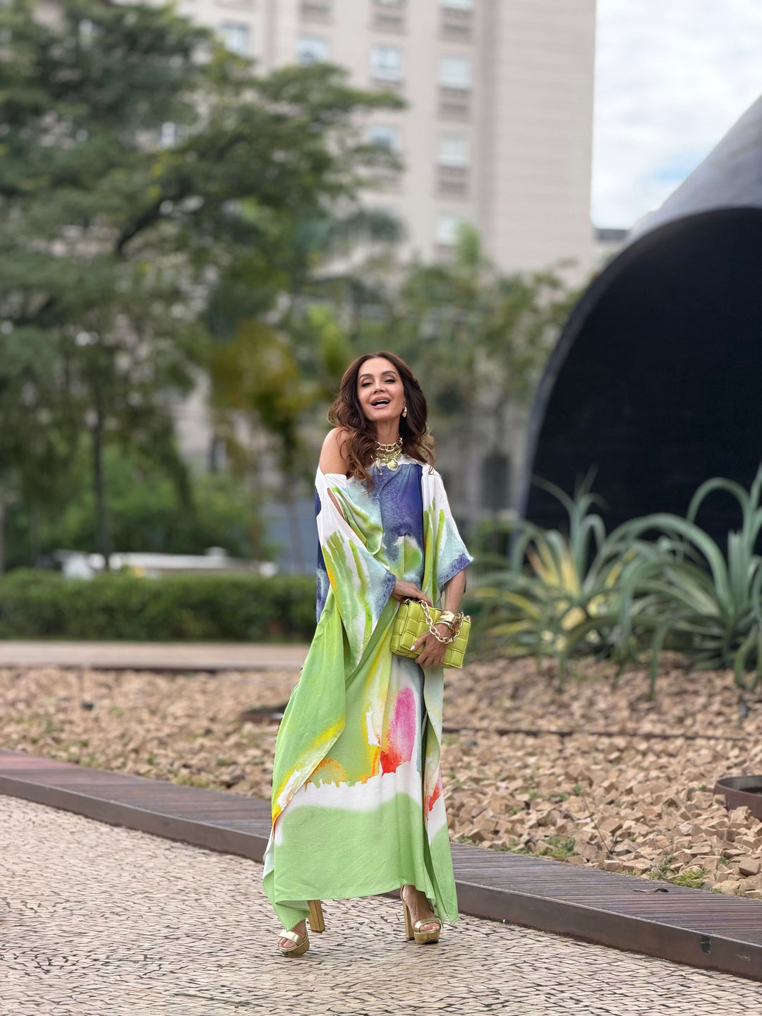 Mulher usando vestido kaftan longo com estampa aquarela colorida ao ar livre