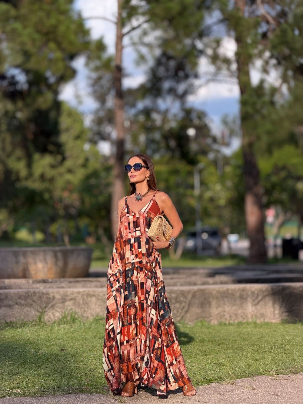 Mulher usando vestido longo de alça com estampa geométrica colorida ao ar livre