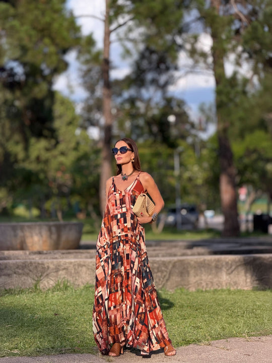Mulher usando vestido longo de alça com estampa geométrica colorida ao ar livre